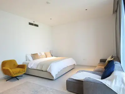 a bedroom with a bed and a chair and a couch at Luxury Living , Beautiful Layout in Dubai