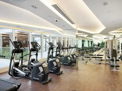 a gym with treadmills and ellipticals in a building at Lux Studio Apt near Butterfly Garden - Pool & Gym in Dubai