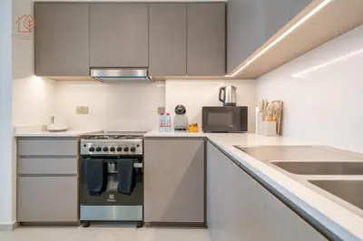 a kitchen with a stove top oven next to a sink at Burj Khalifa Views 2-Bedroom Apartment 203GR-2 in Dubai