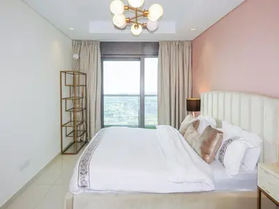 a bedroom with a large white bed with a window at High Floor , Premium 1 Bedroom , Stunning Views in Dubai