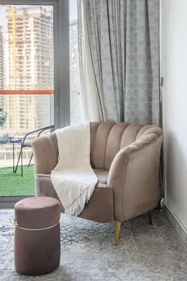 a brown couch in a room with a window at Frank Porter - Millennium Binghatti Residences in Dubai