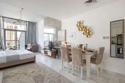 a living room with a dining table and a bedroom at Frank Porter - Millennium Binghatti Residences in Dubai