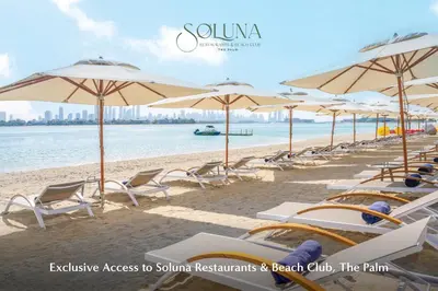 a beach with chairs and umbrellas and the ocean at Grand Millennium Business Bay in Dubai
