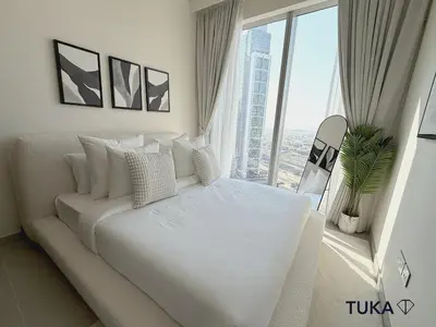 a white bed in a room with a large window at 2BR Forte Tower 1 Downtown 3mn Burj Khalifa in Dubai