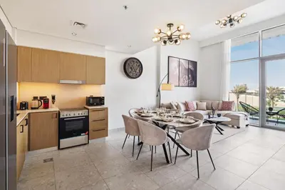 a kitchen and living room with a table and chairs at Luxury 2 Bedroom in Golf Suites Dubai Hills in Dubai