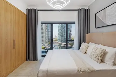 a bedroom with a large bed and a large window at Chic Studio in Goldcrest Views, JLT in Dubai