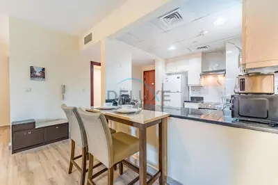 a kitchen with a wooden table and chairs at Lovely Studio in Murjan 2, Jumeirah Beach Residence by Deluxe Holiday Homes in Dubai