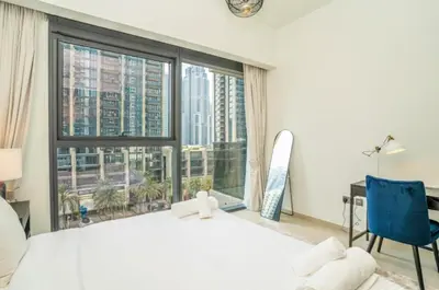 a bedroom with a large white bed and a large window at Luxury Apartment ACT One Act Two 7 Min Walk to Burj Khalifa & Dubai Mall in Dubai