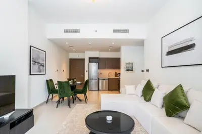 a living room with a white couch and a table at Luxury Apartment ACT One Act Two 7 Min Walk to Burj Khalifa & Dubai Mall in Dubai