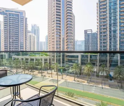 a balcony with a table and chairs and a view of a city at Luxury Apartment ACT One Act Two 7 Min Walk to Burj Khalifa & Dubai Mall in Dubai