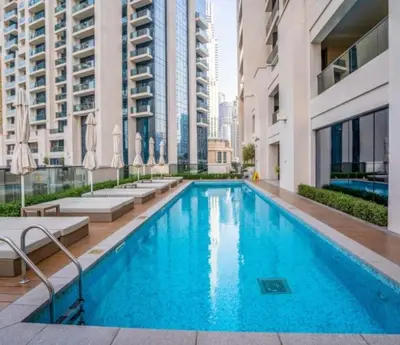 a swimming pool in a building with tall buildings at Luxury Apartment ACT One Act Two 7 Min Walk to Burj Khalifa & Dubai Mall in Dubai
