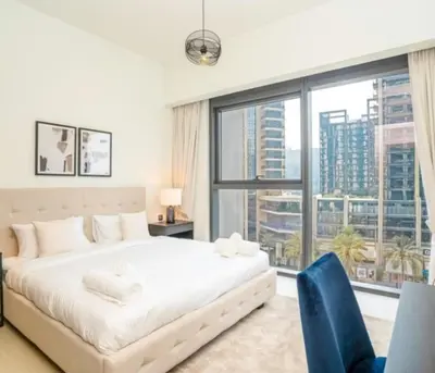 a bedroom with a white bed and a large window at Luxury Apartment ACT One Act Two 7 Min Walk to Burj Khalifa & Dubai Mall in Dubai