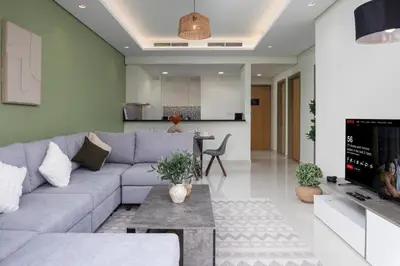 a living room with a gray couch and a tv at Downtown Skyline & Burj Khalifa Views Dubai in Dubai