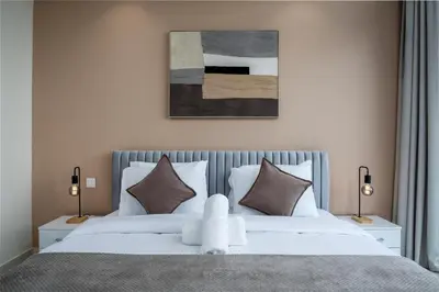 a bedroom with a large white bed with two lamps at Downtown Skyline & Burj Khalifa Views Dubai in Dubai