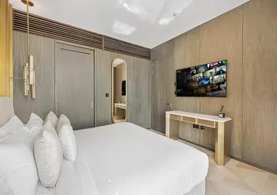 a bedroom with a large white bed and a table at Daniels Sea View 2BR at Five Palm Jumeirah in Dubai