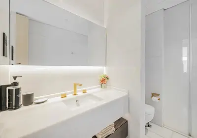 a white bathroom with a sink and a mirror at Daniels Sea View 2BR at Five Palm Jumeirah in Dubai