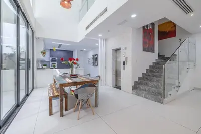 a dining room with a table and a staircase at Coastal Themed 4BR Townhouse with Pool in JVC in Dubai