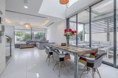 a dining room with a wooden table and chairs at Coastal Themed 4BR Townhouse with Pool in JVC in Dubai