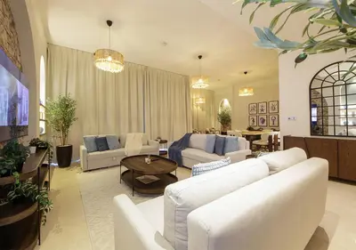 a living room with white couches and a table at Breathtaking Villa With Roof Garden and Beach access in Dubai