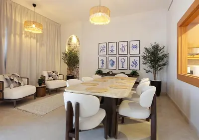 a dining room with a table and white chairs at Breathtaking Villa With Roof Garden and Beach access in Dubai