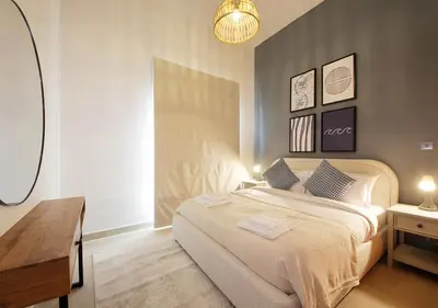 a bedroom with a bed and a desk and a lamp at Breathtaking Villa With Roof Garden and Beach access in Dubai
