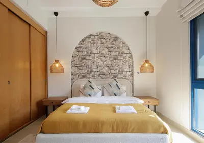 a bedroom with a large bed with a stone wall at Breathtaking Villa With Roof Garden and Beach access in Dubai