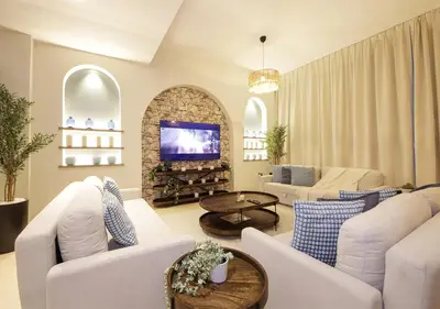 a living room with white furniture and a tv at Breathtaking Villa With Roof Garden and Beach access in Dubai