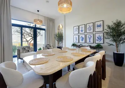 a dining room with a table and white chairs at Luxury Villa With breathtaking View And Beach Access in Dubai