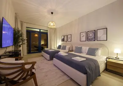 a living room with two beds and a flat screen tv at Luxury Villa With breathtaking View And Beach Access in Dubai