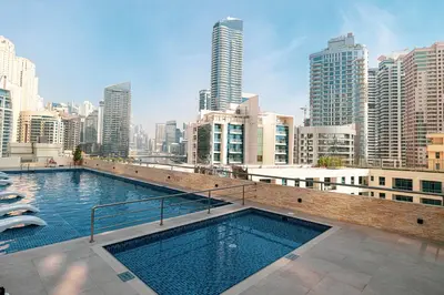 a large swimming pool in a city with tall buildings at Cozy Urban 2BR Apartment in DEC Tower Marina in Dubai