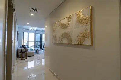 a hallway with a painting hanging on a wall at Stunning 3BR w Panoramic Views in Aykon City in Dubai