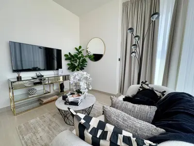 a living room with a couch and a tv at Trendy & Elegant 1br In Jvc in Dubai
