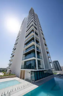 a tall building with a pool in front of it at Trendy & Elegant 1br In Jvc in Dubai