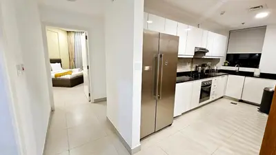 a large kitchen with a stainless steel refrigerator at Elegant 2-Bedroom Apartment with Private Balconies & En-Suite Luxury in Meydan Avenue in Dubai