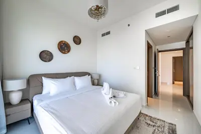 a bedroom with a large white bed and a mirror at Homes Beyond l 2BR Panoramic Skyline & Sea View in Dubai