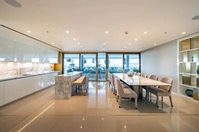 an open kitchen and dining room with a table and chairs at Homes Beyond l 2BR Panoramic Skyline & Sea View in Dubai