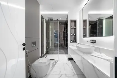 a white bathroom with a toilet and a sink at Business Bay 1BR Canal Views, Pool, Gym & Near Burj Khalifa in Dubai