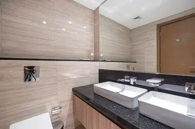a bathroom with two sinks and a large mirror at Mahogany 2 - 2BR 6PAX - Infinity Pool & Near Metro in Dubai