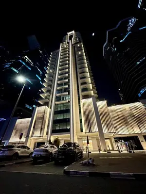 a large building with cars parked in front of it at night at Mahogany 2 - 2BR 6PAX - Infinity Pool & Near Metro in Dubai