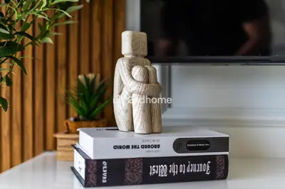 a wooden figurine of a couple on a stack of books at Modern 1-BR Golf Course View in Golf Vita in Dubai