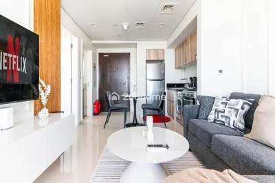 a living room with a couch and a table at Modern 1-BR Golf Course View in Golf Vita in Dubai