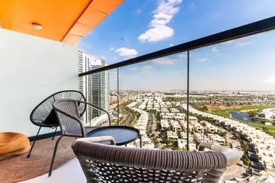 a balcony with two chairs and a table at Modern 1-BR Golf Course View in Golf Vita in Dubai