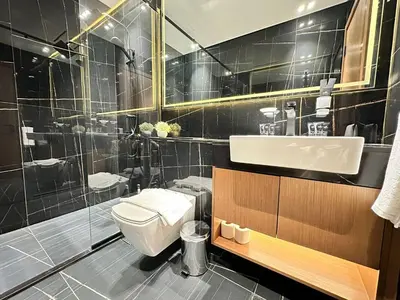 a bathroom with a toilet and a sink and a shower at Chic & Modern 1br Apt Balcony Pool Parking in Dubai