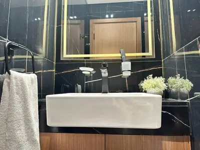 a bathroom with a white sink and a mirror at Chic & Modern 1br Apt Balcony Pool Parking in Dubai