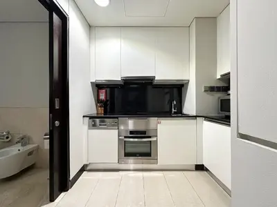 a kitchen with a stove and a microwave at Trophy - Marina Address Studio - Full Marina View in Dubai
