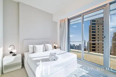 a bedroom with a white bed and a large window at LUX The Premium Marina Sea View Suite in Dubai