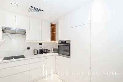 a white kitchen with white cabinets and appliances at LUX The Premium Marina Sea View Suite in Dubai
