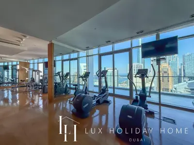 a gym with cardio equipment in a building with a view at LUX The Premium Marina Sea View Suite in Dubai