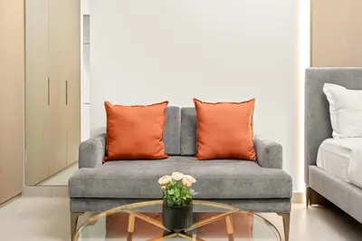 a living room with a couch and a glass table at FIRST CLASS Studio Stylish Living in Dubai
