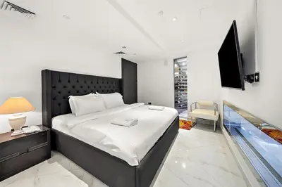 a bedroom with a large bed and a television at Elegant 2BR with Burj Views, Pool, Gym, and Quick Metro Access in Dubai